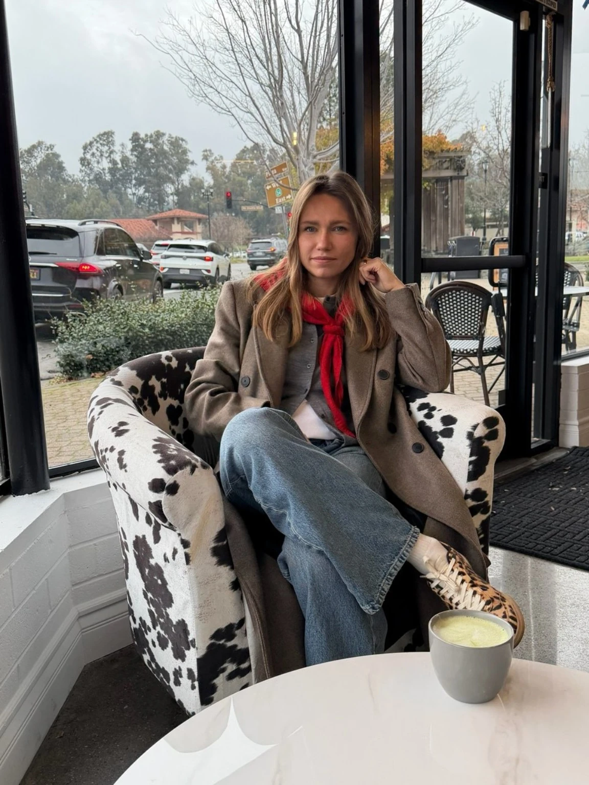 Jenny wearing a versatile layered autumn outfit in a cafe